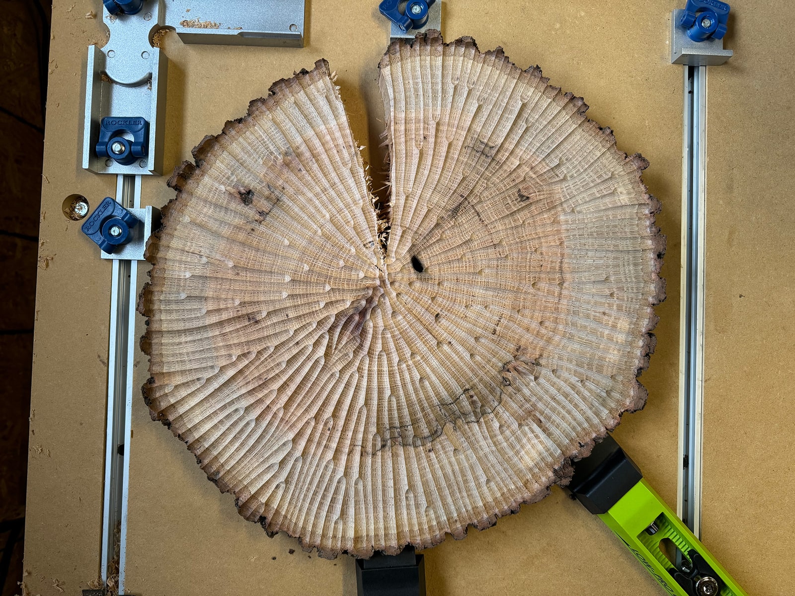 Oak slice mid-cut in the CNC, radial gradient pattern emerging across the surface